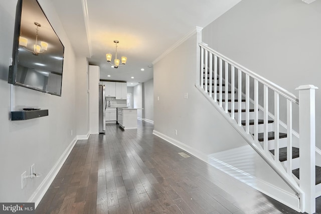 staircase featuring crown molding, hardwood / wood-style floors, and a chandelier