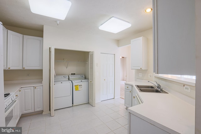 kitchen with white cabinetry, light tile patterned floors, sink, gas range gas stove, and separate washer and dryer