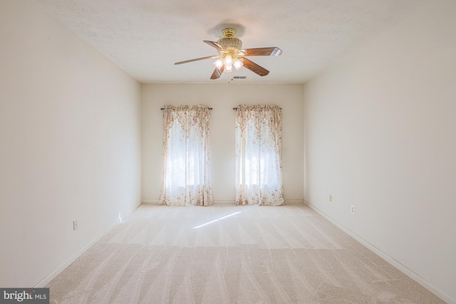 unfurnished room featuring ceiling fan, light colored carpet, and a textured ceiling