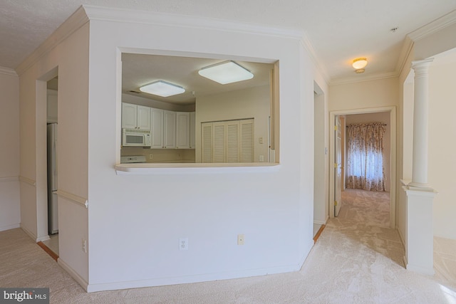 corridor with decorative columns, light colored carpet, and crown molding