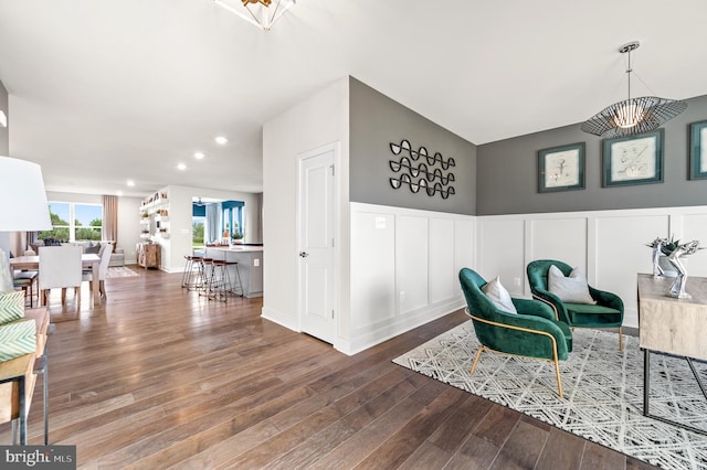 sitting room with hardwood / wood-style flooring and a chandelier