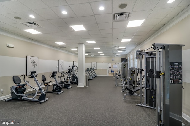 gym with a paneled ceiling and ornamental molding