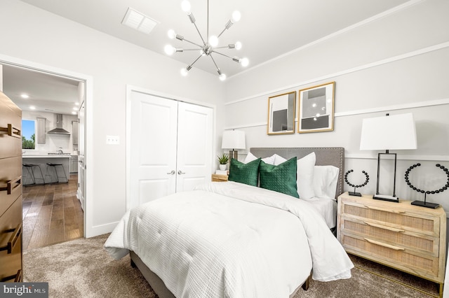 bedroom featuring hardwood / wood-style floors, a chandelier, and a closet