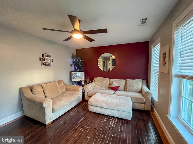 living room with a healthy amount of sunlight, ceiling fan, and dark wood-type flooring