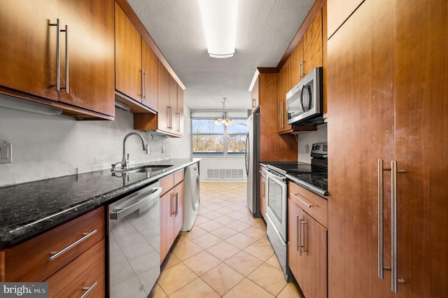 kitchen featuring a chandelier, decorative light fixtures, light tile patterned floors, appliances with stainless steel finishes, and sink