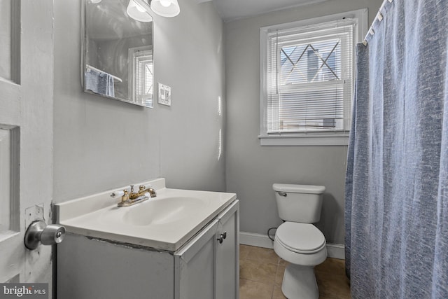 bathroom with toilet, vanity, and tile patterned floors