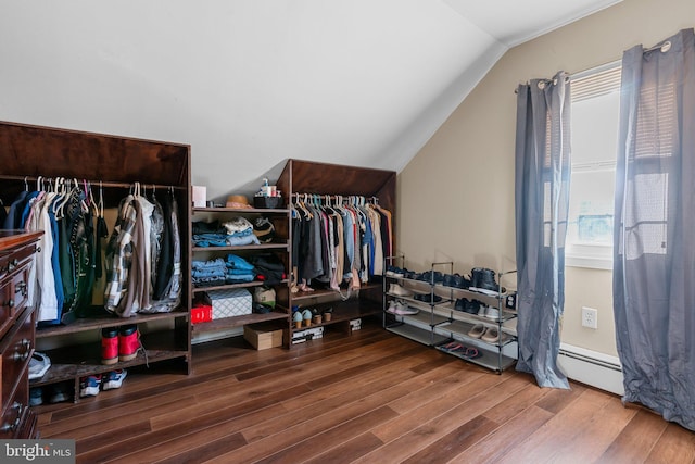 walk in closet with hardwood / wood-style floors, a baseboard radiator, and vaulted ceiling