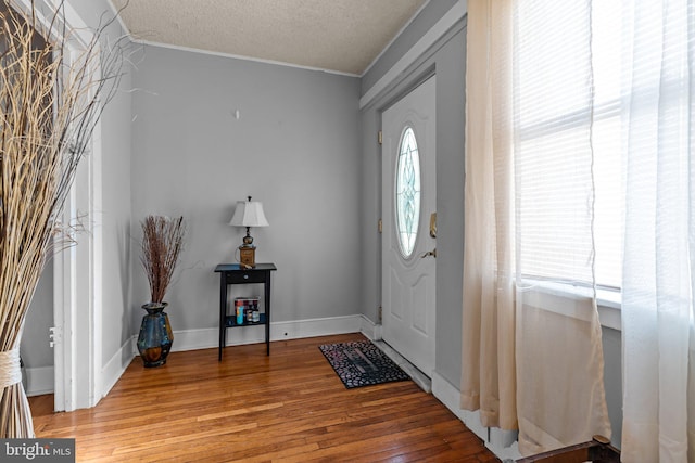 entryway featuring hardwood / wood-style floors, a textured ceiling, and crown molding