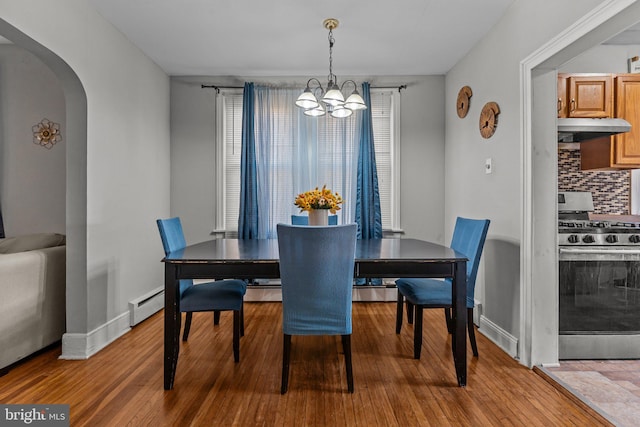 dining room featuring a chandelier, wood-type flooring, and baseboard heating