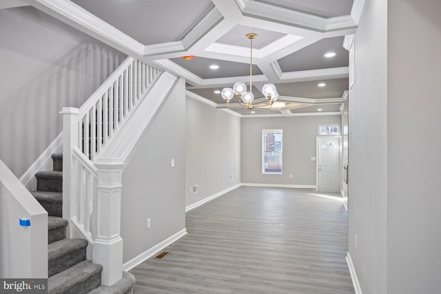 interior space featuring coffered ceiling, crown molding, wood-type flooring, a notable chandelier, and beamed ceiling