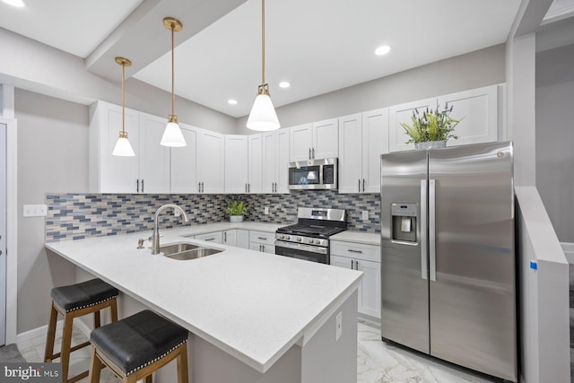 kitchen featuring white cabinets, appliances with stainless steel finishes, kitchen peninsula, and a kitchen breakfast bar