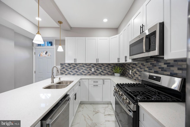 kitchen featuring decorative backsplash, stainless steel appliances, white cabinetry, and sink