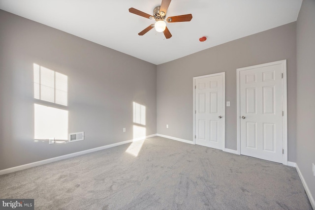 carpeted empty room featuring ceiling fan