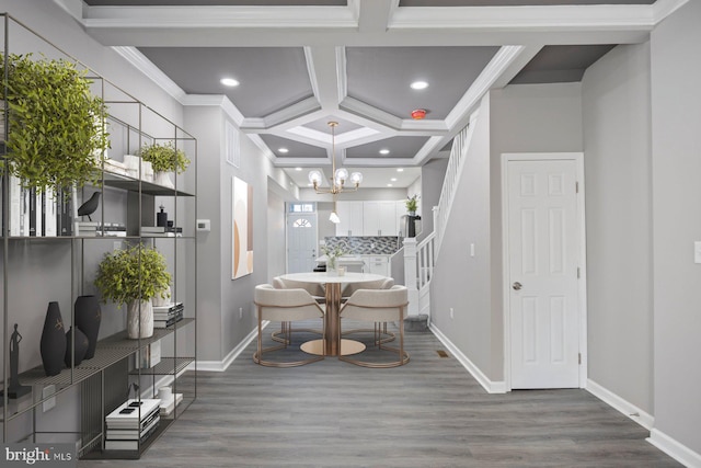 interior space with hardwood / wood-style floors, an inviting chandelier, crown molding, and coffered ceiling