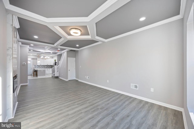 unfurnished living room with crown molding, a fireplace, light hardwood / wood-style floors, and coffered ceiling