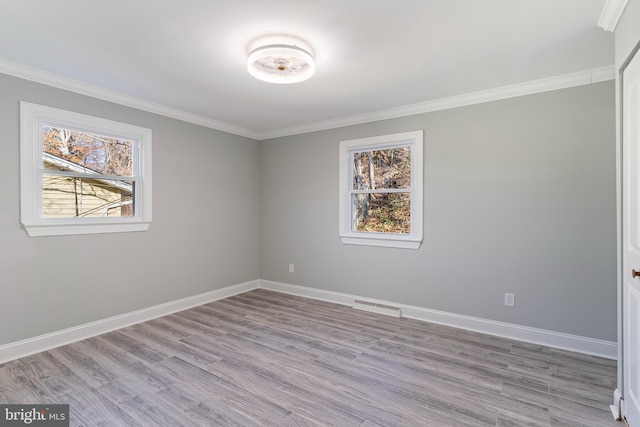 unfurnished room featuring plenty of natural light, light wood-type flooring, and crown molding