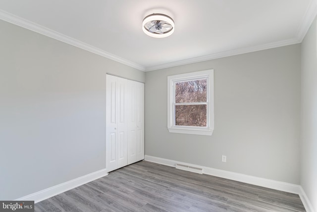 spare room featuring hardwood / wood-style floors and ornamental molding