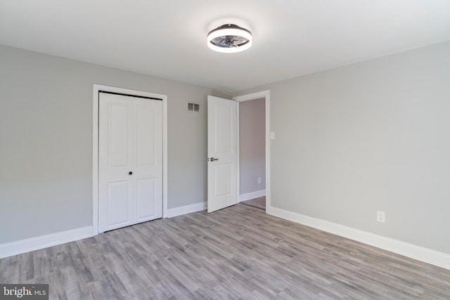 unfurnished bedroom featuring light hardwood / wood-style floors and a closet