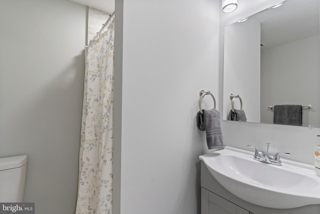 bathroom with vanity, a shower with shower curtain, and toilet