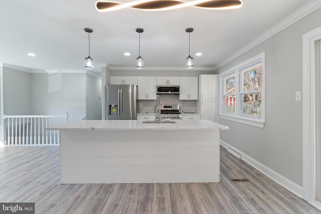 kitchen featuring hanging light fixtures, white cabinetry, light hardwood / wood-style flooring, and stainless steel appliances