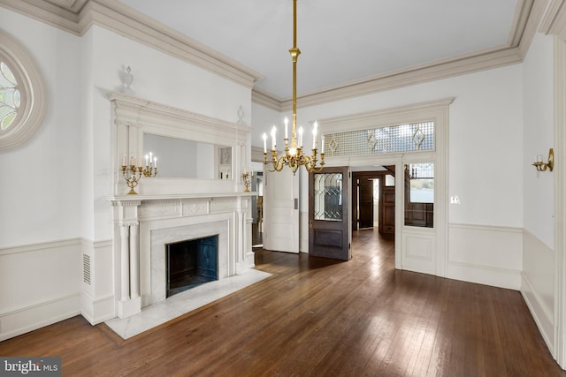 unfurnished dining area with a fireplace, dark hardwood / wood-style floors, a chandelier, and ornamental molding