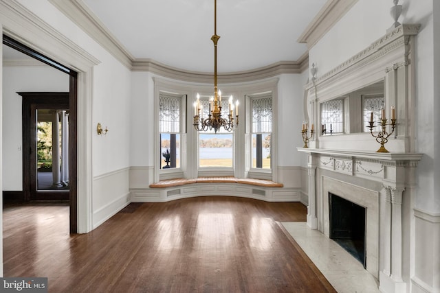 unfurnished dining area featuring a fireplace, wood-type flooring, plenty of natural light, and a notable chandelier