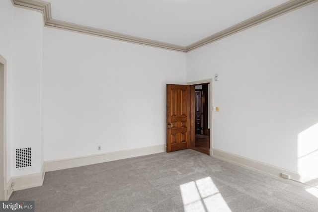 carpeted empty room featuring crown molding