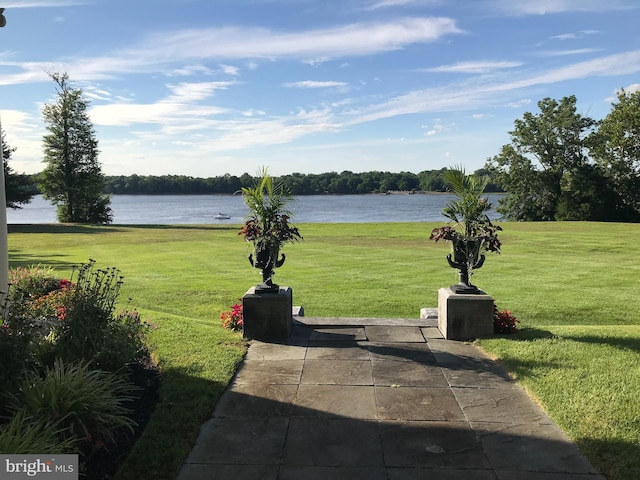 view of property's community featuring a lawn and a water view