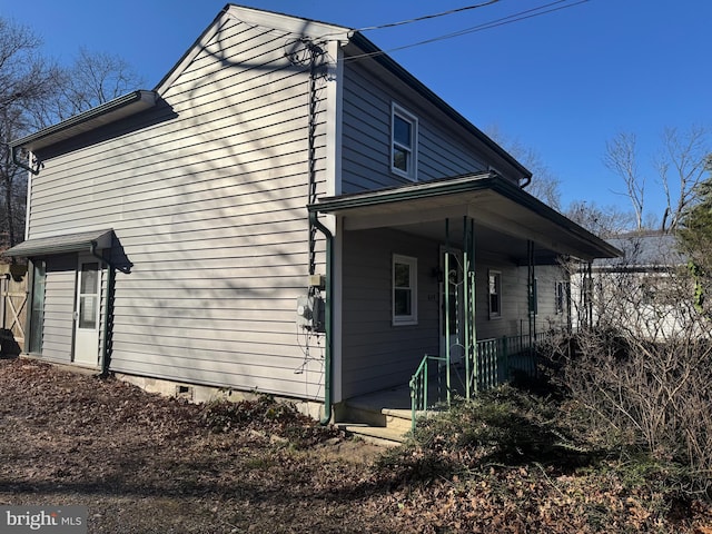 view of side of home featuring covered porch