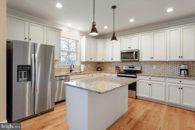 kitchen with appliances with stainless steel finishes, white cabinetry, and a center island