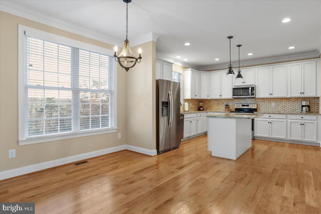 kitchen featuring a kitchen island, white cabinetry, pendant lighting, and appliances with stainless steel finishes