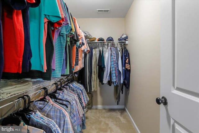 spacious closet featuring light colored carpet