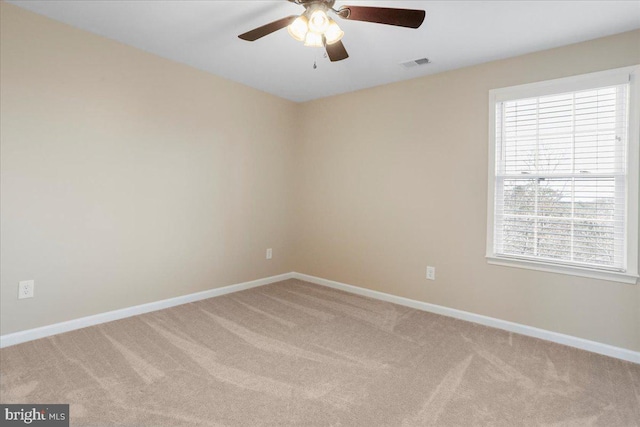 carpeted spare room featuring ceiling fan