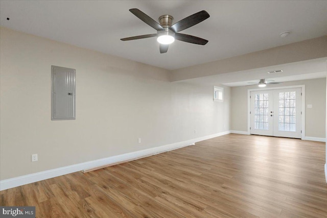 spare room featuring electric panel, ceiling fan, french doors, and light hardwood / wood-style floors