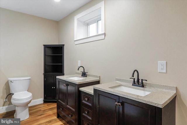 bathroom with toilet, hardwood / wood-style flooring, and vanity