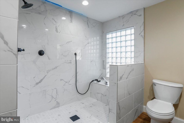 bathroom with toilet and a tile shower