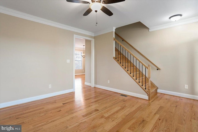 interior space featuring ceiling fan with notable chandelier, light hardwood / wood-style floors, and crown molding