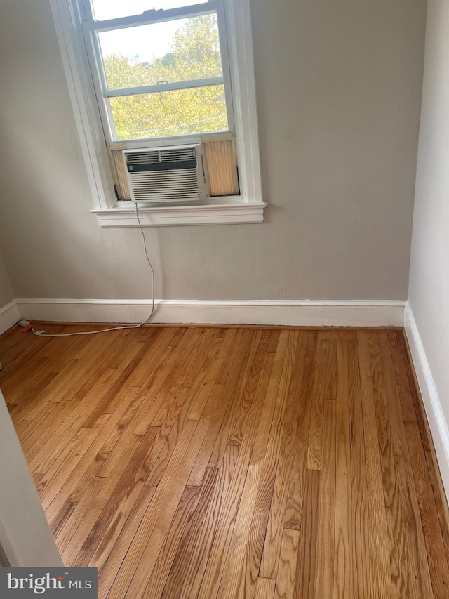 unfurnished room with light wood-type flooring and cooling unit