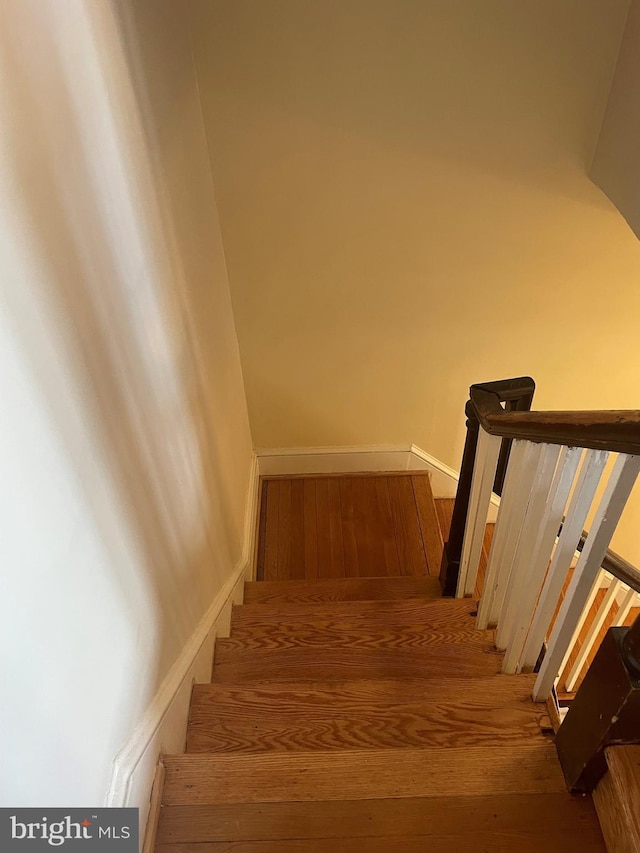 stairs featuring hardwood / wood-style floors