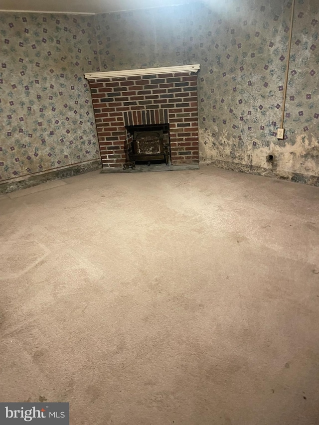 unfurnished living room featuring a fireplace and carpet floors