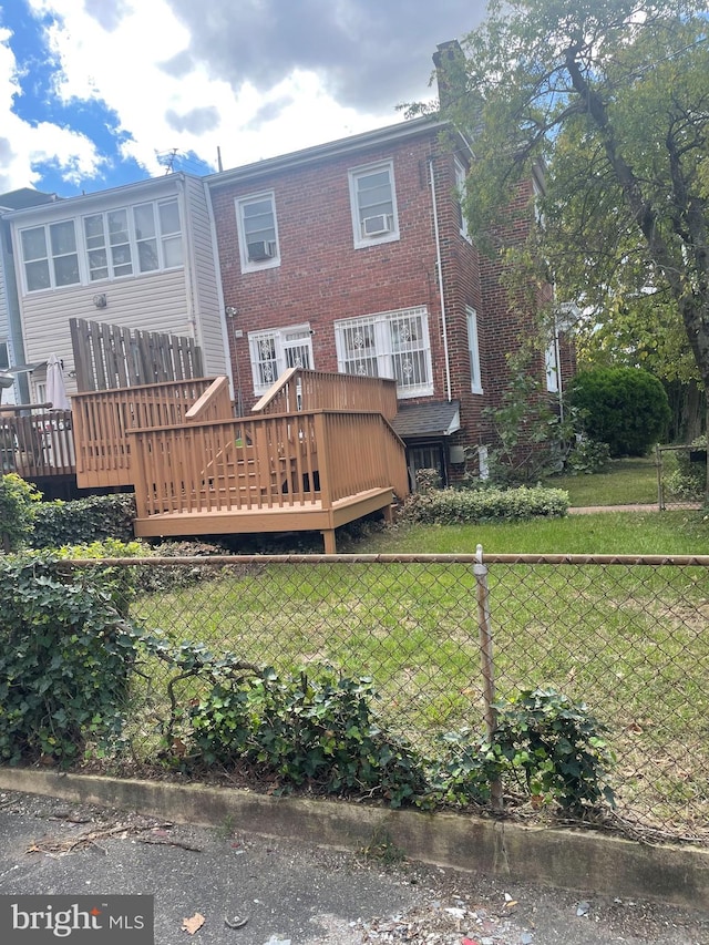 back of house featuring a lawn and a deck