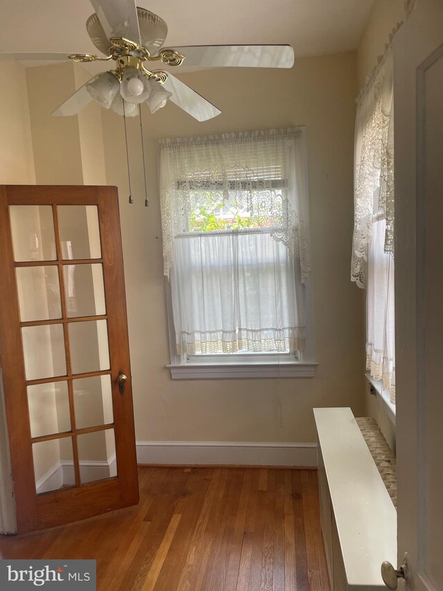 unfurnished dining area featuring hardwood / wood-style flooring and ceiling fan