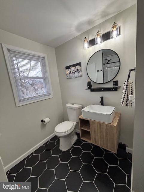 bathroom with walk in shower, tile patterned flooring, vanity, and toilet