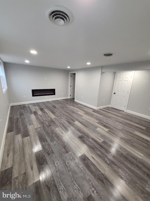 basement with dark hardwood / wood-style floors