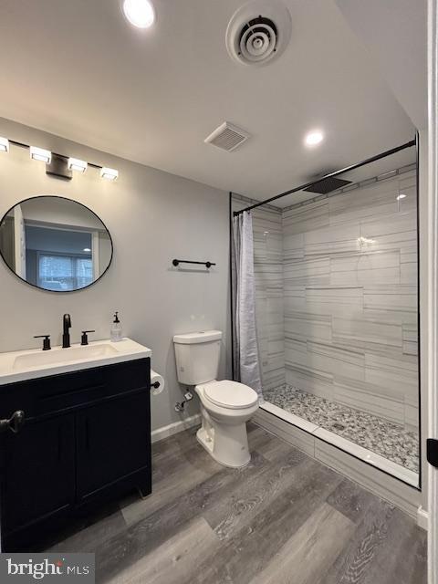 bathroom featuring wood-type flooring, vanity, toilet, and a shower with curtain