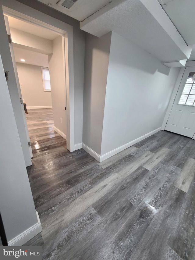 additional living space featuring dark wood-type flooring and a textured ceiling