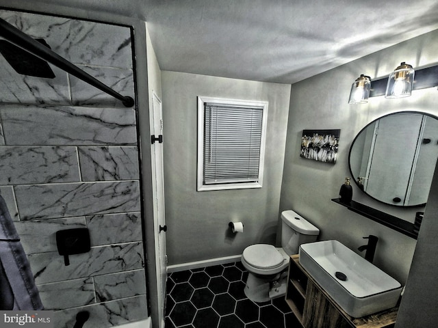 bathroom with a tile shower, toilet, tile patterned floors, and sink