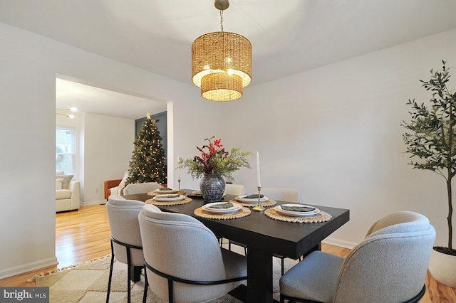 dining area with light wood-type flooring and a chandelier