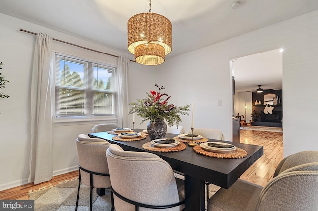 dining area featuring light hardwood / wood-style floors and ceiling fan with notable chandelier