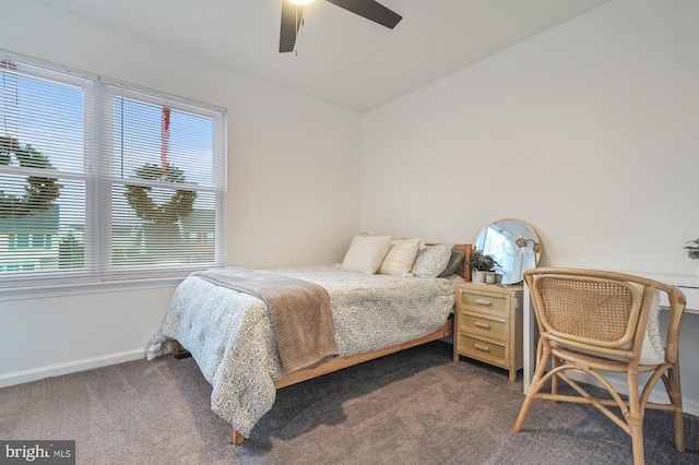 bedroom with dark colored carpet, ceiling fan, and lofted ceiling